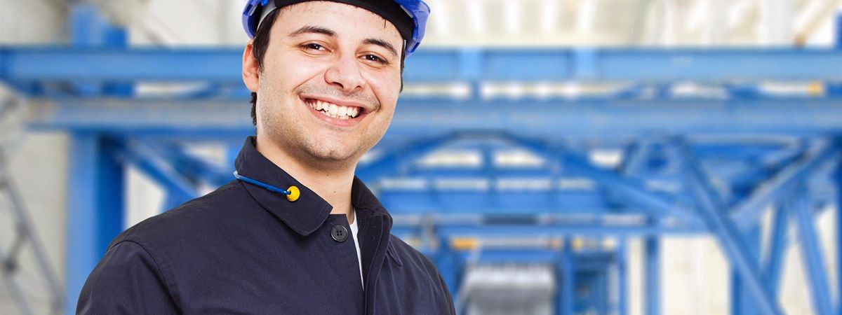 Smiling man wearing a hard hat in a plant